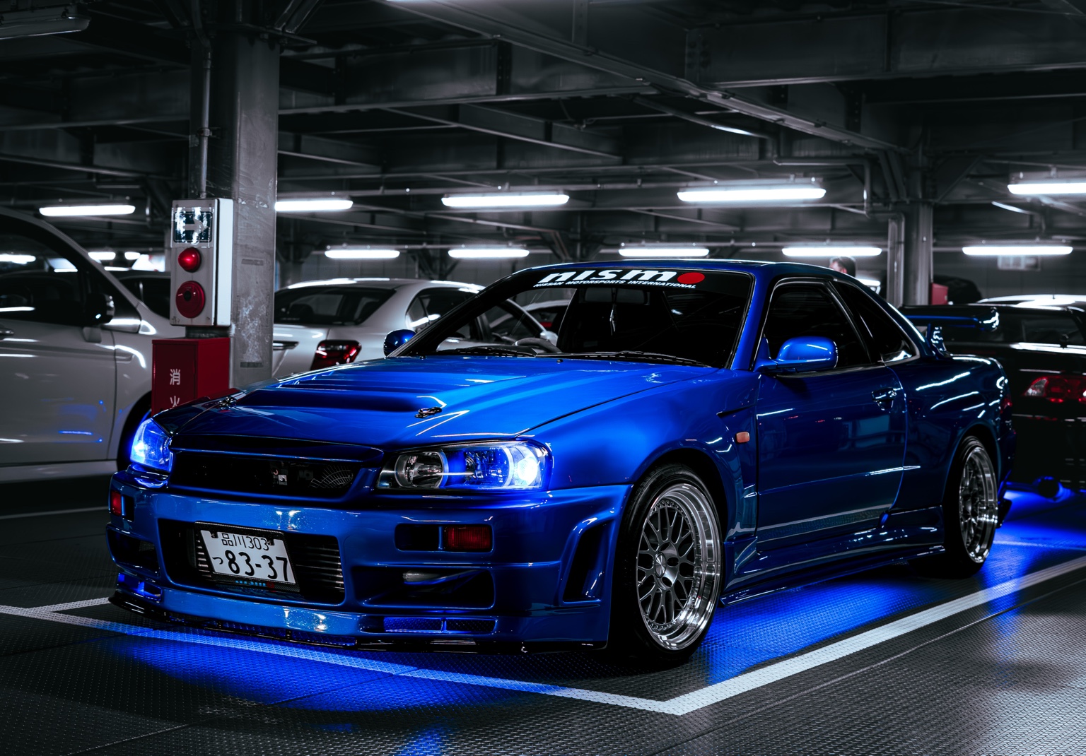 Blue R34 GT-R inside a parking area